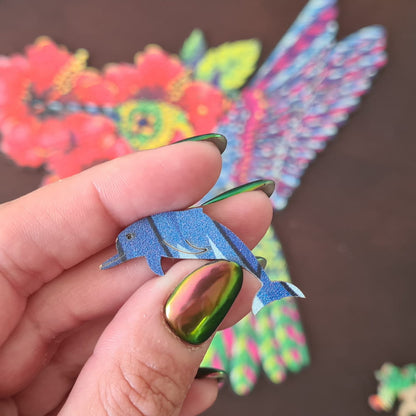 Mão segurando peça de quebra-cabeça de madeira em formato de boto.