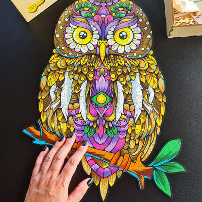 Uma mão na frente do quebra-cabeça da Coruja para ver a proporção de tamanho