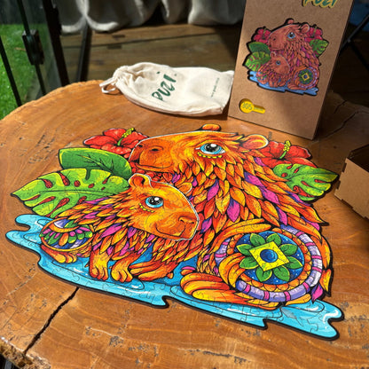 Quebra-cabeça de capivara da marca Puzi finalizado sobre mesa de madeira com embalagem ao fundo.