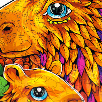 Close-up em alta definição do quebra-cabeça mostrando os detalhes da impressão UV na capivara e os cortes a laser que formam silhuetas de outros animais brasileiros